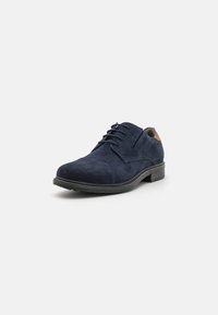 Scarpa stringata in suede blu navy con punta tondeggiante, accentuata da un tacco marrone a contrasto e suola in gomma texturizzata. Dettagli di cucitura curati e visibili.