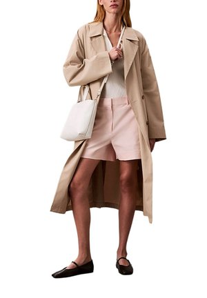 Trench beige, borsa bianca, top bianco aderente, pantaloncini rosa chiaro e ballerine nere. Il cappotto presenta un colletto classico e bottoni.