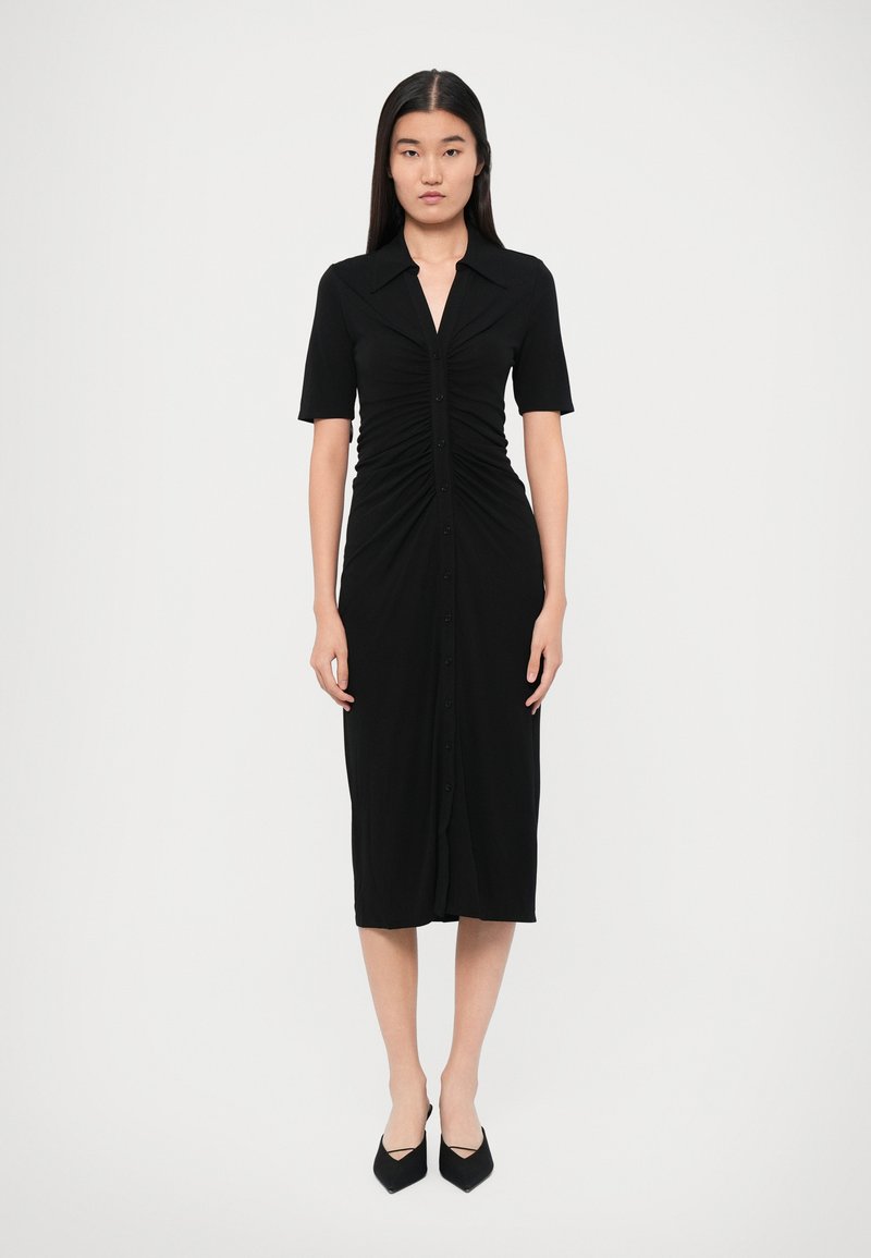 Robe noire midi à manches courtes, boutonnière sur le devant et design froncé à la taille. Tissu doux avec une silhouette ajustée.