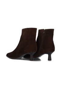 Brown suede ankle boots with a tapered shape, featuring a rear zipper, 3-inch curved heel, and smooth texture.