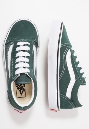 Grüne Vans-Sneaker aus Canvas mit weißen Schnürsenkeln und dem charakteristischen Seitenstreifen, von oben und von der Seite auf weißem Hintergrund gezeigt.