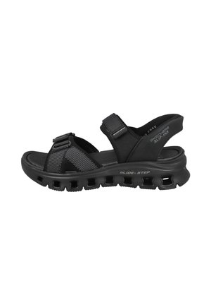 Sandalia negra Skechers Glide-Step tipo slip-on con correas ajustables, suela acolchada y suela exterior ventilada para mayor comodidad y transpirabilidad.