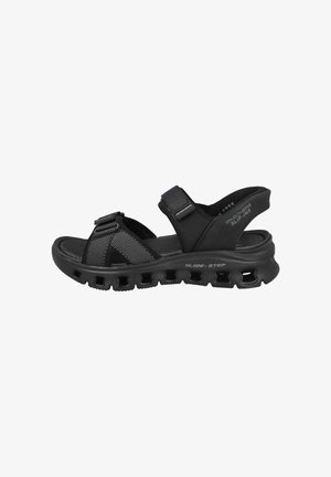 Sandalia negra Skechers Glide-Step tipo slip-on con correas ajustables, suela acolchada y suela exterior ventilada para mayor comodidad y transpirabilidad.
