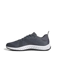 Gray athletic shoes featuring a textured fabric upper, contrasting rubber sole, and a streamlined design. Includes lace-up closure and padded collar.