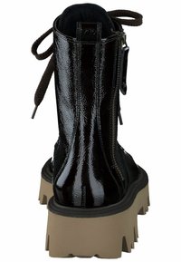 Černá kotníková bota z lesklé lakované kůže s robustní béžovou podrážkou, zadním zipem a hnědými tkaničkami. Má hladký, lesklý povrch.