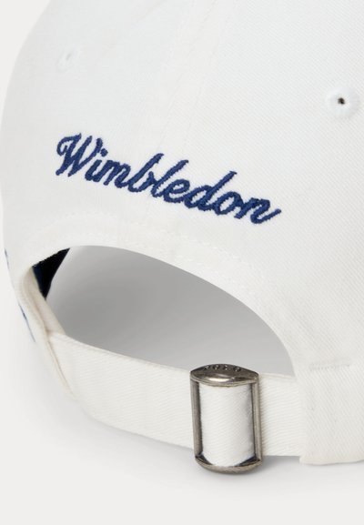 Λευκό καπέλο με κέντημα “Wimbledon” σε ναυτικό μπλε πάνω από ρυθμιζόμενο μεταλλικό κούμπωμα στο πίσω μέρος.