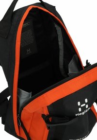 Mochila negra y naranja con una apertura con cremallera, compartimentos interiores, tela texturizada y un logo en la parte delantera. El interior es gris.