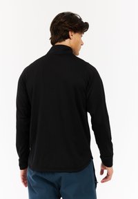 Zwarte langemouwen shirt met een gestructureerd patroon en een kraag. Het shirt heeft een relaxte pasvorm, met lange mouwen en een ronde zoom.