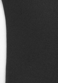 Nahaufnahme eines schwarz-weißen Stoffes mit einer glatten, strukturierten Oberfläche und vertikalen Rippungen; kontrastierende Farben nebeneinander.