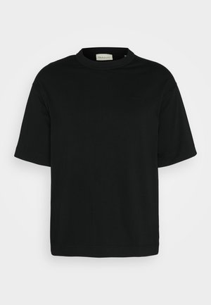 Sort kortærmet T-shirt lavet af blød bomuld. Har en rund halsudskæring og et minimalistisk design med et præget logo på brystet.
