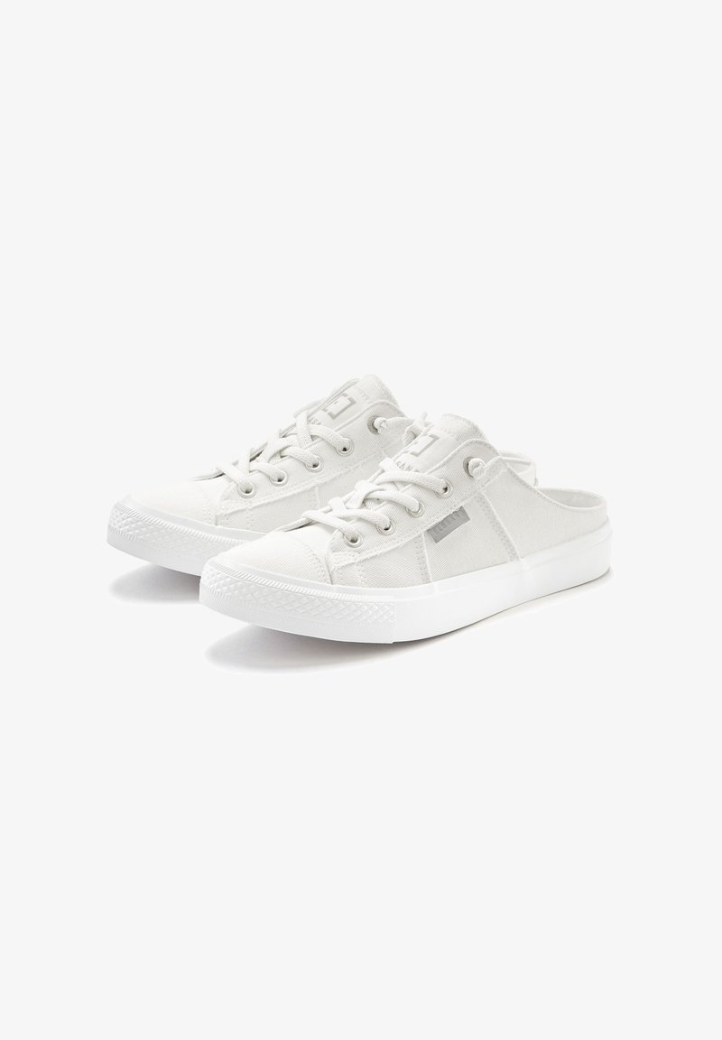 Weiße schlichte Slip-On-Schuhe aus Canvas mit strukturiertem Obermaterial, versehen mit Schnürdetails, runder Gummikappe und flacher weißer Sohle.