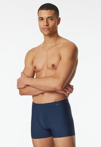 Boxer briefs blu navy con texture a righe verticali, vita elastica e piccolo logo; design aderente.