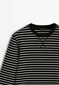 T-shirt noir à col rond avec fines rayures horizontales blanches et col côtelé, présenté à plat sur un fond blanc.