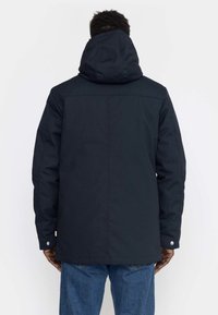 Navy hooded jacket with a smooth texture, featuring a straight cut, adjustable hood, and snap button details at the cuffs.