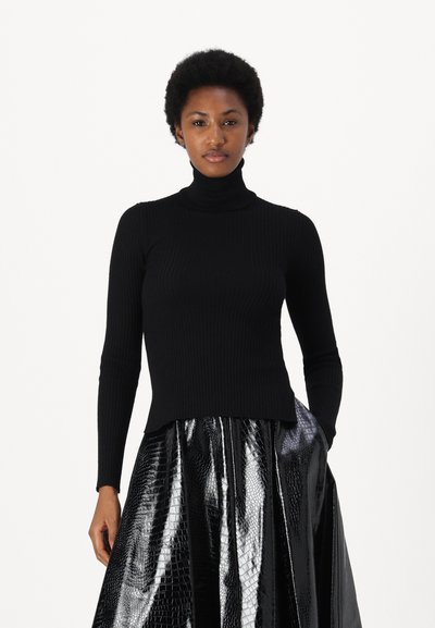 Pulover negru cu guler înalt și dungi, cu mâneci lungi, asortat cu o fustă neagră lucioasă, cu un model de crocodil și siluetă cloș.