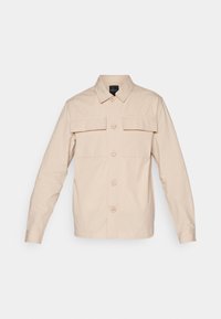 Camisa de botón de color beige claro con cuello, dos bolsillos frontales y mangas largas, hecha de una tela texturizada.