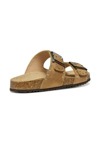 Bruine suede schuifsandalen met dubbele gespen, zilveren studs en een gestructureerde kurken voetbed. Heeft een open teen en een gebogen voetbed ontwerp.