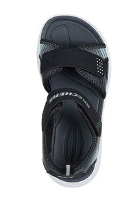 Sandalia negra con correas ajustables, plantilla texturizada y suela blanca. Presenta sutiles acentos grises y la marca Skechers en la correa.