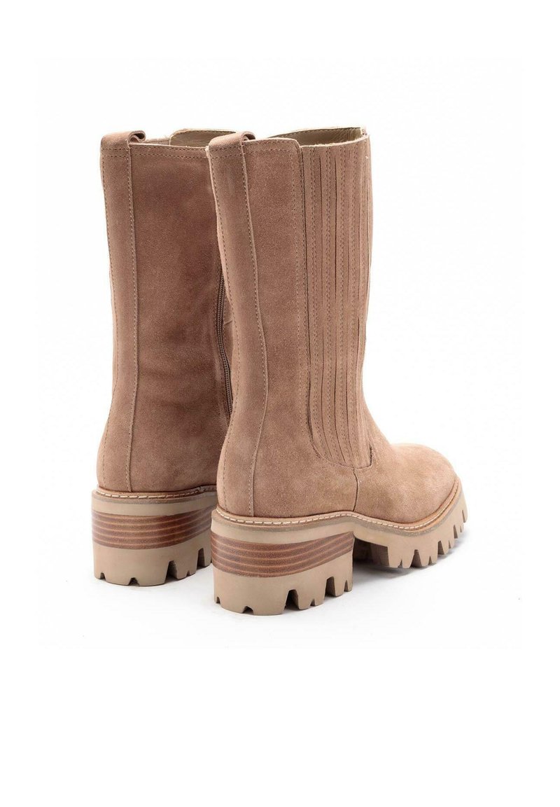 Botas de tobillo de ante en beige claro con paneles laterales acanalados y suelas gruesas y estriadas con acentos en capas. Diseño de punta redonda.