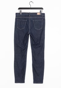 Jeans de mezclilla azul oscuro con un corte ajustado, que cuentan con dos bolsillos traseros, costuras en contraste y una etiqueta en la cinturilla.