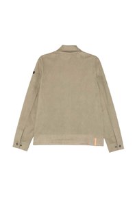 Giacca in suede beige chiaro con colletto, maniche lunghe e polsini con bottone. Presenta un'etichetta arancione a contrasto sull'orlo e una branding minimale.