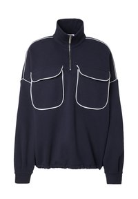 Marineblauwe pullover met hoge kraag en ritssluiting. Voorzien van witte piping langs de schouders en twee grote zakken aan de voorkant. Zachte textuur.