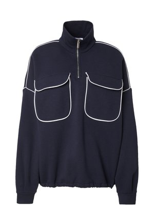 Navy Pullover mit hohem Kragen und Reißverschluss. Mit weißen Paspeln an den Schultern und zwei großen Fronttaschen. Weicher Stoff.