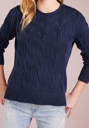 Marineblå kabelstrikket sweater med ribbet halsudskæring og manchetter. Har et struktureret mønster og en kant, der sidder let til kroppen.