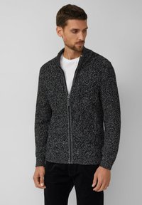 Cardigan zip-up in nero e grigio realizzato in tessuto a maglia testurizzato; presenta un colletto alto e un colore uniforme in tutta la sua lunghezza.