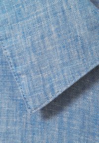 Tessuto azzurro chiaro con una texture sottile e un motivo delicato. Il materiale sembra intrecciato con fibre visibili e una finitura liscia. I bordi sono cuciti in modo ordinato.