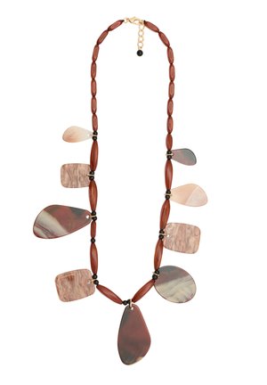 Una collana con pietre di forme e colori variabili nelle tonalità marroni e crema, intervallate da perle di ambra allungate e accenti neri.