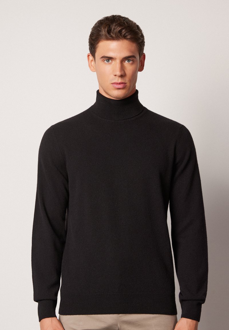 Schwarzer Rollkragenpullover aus weichem Strickstoff, mit langen Ärmeln und gerippten Bündchen und Saum, glatte Textur mit minimaler Detailgestaltung.