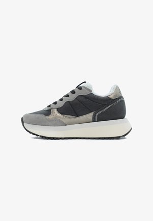 Grijze suède en textiel sneaker met een gestructureerde afwerking, zwarte veters, witte tussenzool en een zachte binnenvoering. Patronen langs de zijkanten.