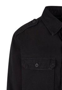 Black button-up shirt with a pointed collar, single chest pocket, and shoulder epaulettes, made from woven fabric with a smooth texture.
