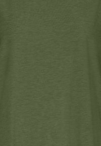 T-shirt en coton léger vert olive avec une texture lisse et un motif chiné subtil. Manches courtes et encolure ronde.