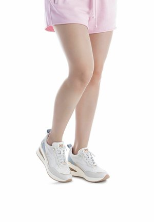 Zapatillas deportivas blancas con acentos azul claro y parte superior de malla texturizada. Presentan una suela gruesa y diseño con cordones.