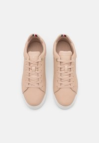 Jasnoróżowe skórzane sneakersy z okrągłym noskiem, płaską białą gumową podeszwą i pasującymi sznurowadłami. Posiadają subtelną markę i teksturowane wykończenie wewnętrzne.