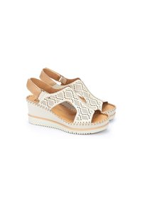Sandali wedge bianchi con tomaia in pelle perforata e cinturino regolabile. Suola texturizzata e dettagli di cucitura discreti.