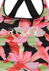Sort svømmetop med stort, farverigt blomstermønster i pink, rød og grøn. Har Roxy-logo i gyldent skrift. Trekantede stropdesign.
