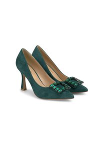 Escarpins en daim vert avec un bout pointu et un talon carré. Une grosse boucle ornée de pierres vertes et noires orne l'avant.