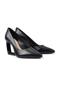 Para czarnych, skórzanych szpilek z ostrym noskiem i wgłębionymi, geometrycznymi obcasami na białym tle.