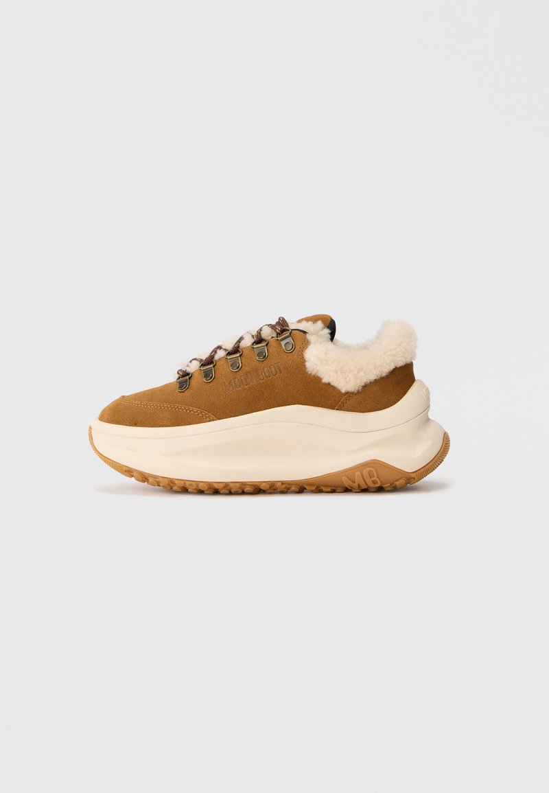 Brune ruskinds sneakers med tyk beige sål, pelsforing, metaløjer og snørebånd i rebstil, med "Moon Boot" og "MB" logo på siden og sålen.