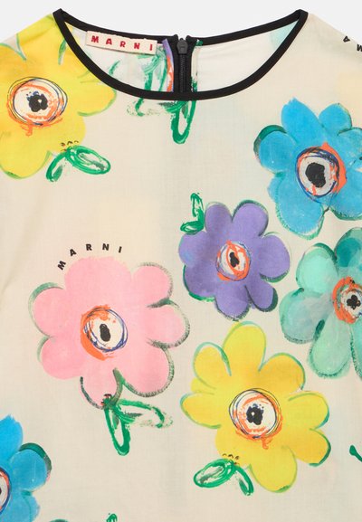 Τοπ με floral σχέδιο που παρουσιάζει μεγάλα πολύχρωμα λουλούδια σε ροζ, κίτρινο, μπλε και μοβ πάνω σε ανοιχτό φόντο. Μαύρη λεπτομέρεια στο ντεκολτέ.