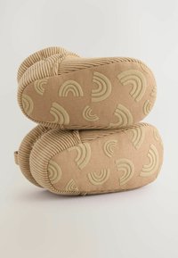 Chaussons en velours côtelé beige avec un talon incurvé, présentant un motif texturé d'arc-en-ciel beige sur les semelles. Apparence douce et moelleuse.