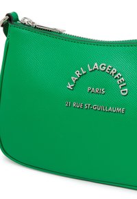 Grön texturerad läderaxelväska med silverfärgad hårdvara och embossade märkes- och adressdetaljer. Bågformad design och dragkedjestängning.