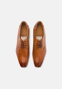 Scarpe eleganti in pelle marrone con finitura lucida, dotate di punta affilata e design classico con lacci. Il marchio è visibile all'interno.