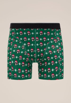 Boxer in cotone verde con elastico nero in vita, caratterizzati da un motivo di cani con cappelli di Babbo Natale e fiocchi di neve. Tessuto morbido.