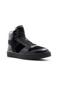 Höga sneakers med en blandning av svart texturerat tyg och glänsande lackläder. Snörningsdesign med en solid gummisula.