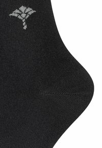 Schwarze Baumwollsocke mit glatter Textur. Verfügt über ein graues Blätterdesign nahe der Oberseite. Abgerundete Ferse und verstärkte Nähte an der Zehe.