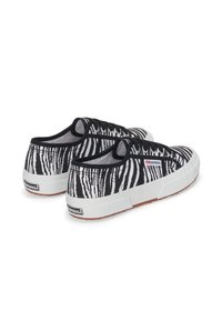Sneakers in tela con motivo zebra in bianco e nero, dotati di lati elasticizzati, suole in gomma bianca e suola texturizzata in gomma. Branding sul lato.